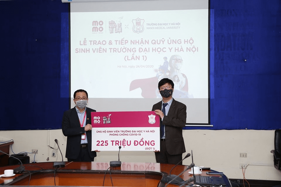Ngày 26/4, đại diện Ví điện tử MoMo trao tặng 225 triệu đồng cho trường Đại học Y Hà Nội để hỗ trợ các bạn sinh viên đang trực tiếp chống dịch. Số tiền trao đợt 1 được quy đổi từ hơn 1,55 triệu Heo vàng.